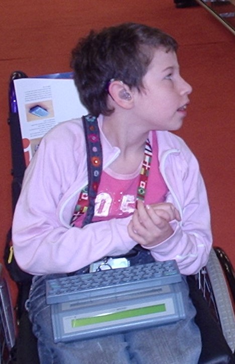 Beth Moulam age 12 wearing hearing aids and with AAC communication aid