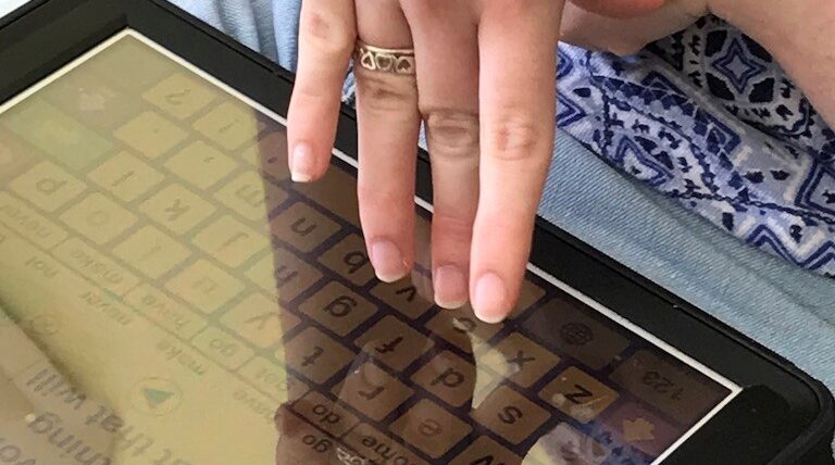 Using AAC confidently and competently, device is an iPad with a yellow and blue screen