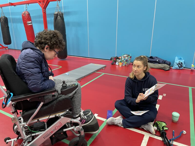 Beth Moulam AAC user with hearing impairment, at boccia, working with communication partner