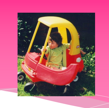 Child in toy car. Using AAC at home.