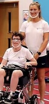 Two women in boccia sports kit wearing covid clear masks for lipreading