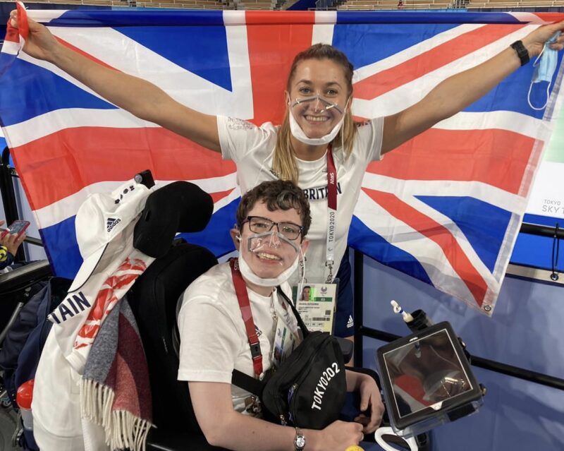Beth Moulam with CP and sports assistant holding a GB flag at Tokyo Paralympics