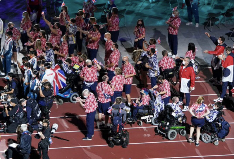 Group of people at the Paralympics Tokyo 2020 closing ceremony wearing red shirts.