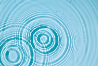 Light blue water with concentric circles or the ripple effect spreading out from central point