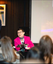 Beth Moulam presenting wearing a pink suit