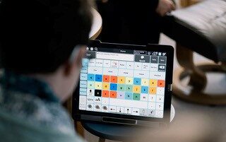 Person looking at a communication device screen with text. AAC